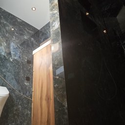 Pro-Efekt Przemysław Zimoch - Nowoczesna łazienka w Kniatowach z marmurowymi płytkami i drewnianą szafką pod umywalkę. Minimalistyczny design i oświetlenie punktowe.