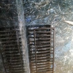 Pro-Efekt Przemysław Zimoch - Łazienka z płytkami imitującymi marmur i czarnym grzejnikiem drabinkowym. Wykończenie z dbałością o detale, nowoczesny design.