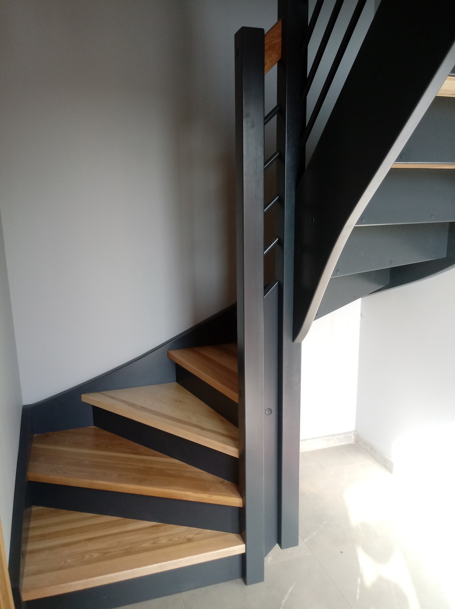 Schody dwu zabiegowe z podstopniami. Jesion naturalny plus antracyt.