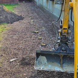 Usunięcie rzędu korzeni po swierkach wraz z utylizacja i wyrównaniem nowa ziemią. 