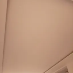 Gładka, beżowa powierzchnia sufitu podwieszanego z delikatnym oświetleniem LED wzdłuż krawędzi, widok z dołu.