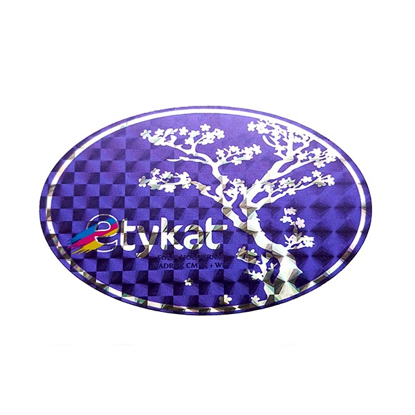 Owalna, holograficzna naklejka z motywem drzewa bonsai i napisem 'etykat' w kolorach CMYK na fioletowym tle w kratkę.