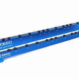 Fotografia i wideografia reklamowa Szymon Kryszczak - Dwie niebieskie listwy Tokado Drillex T200 z numerowanymi otworami, ułożone równolegle na białym tle. Produkt obróbki CNC, precyzyjnie wykonany, z logo firmy.