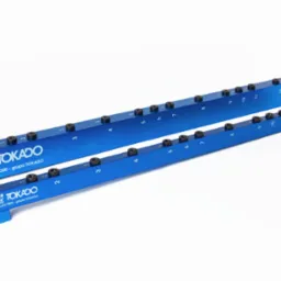 Dwie niebieskie listwy Tokado Drillex T200 z numerowanymi otworami, ułożone równolegle na białym tle. Produkt obróbki CNC, precyzyjnie wykonany, z logo firmy.