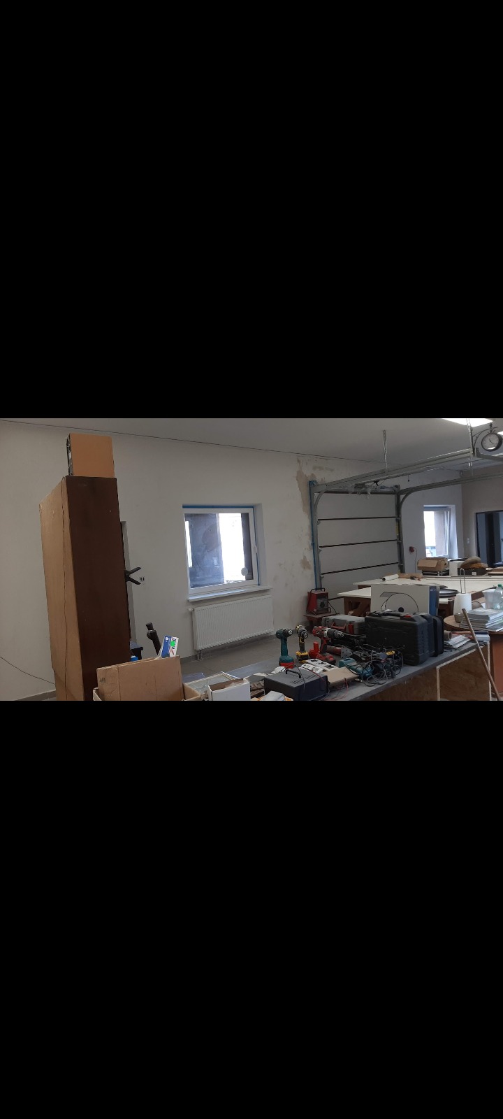 Przygotowanie do prac remontowych wewnątrz budynku: widoczne narzędzia, materiały i niedokończone ściany.