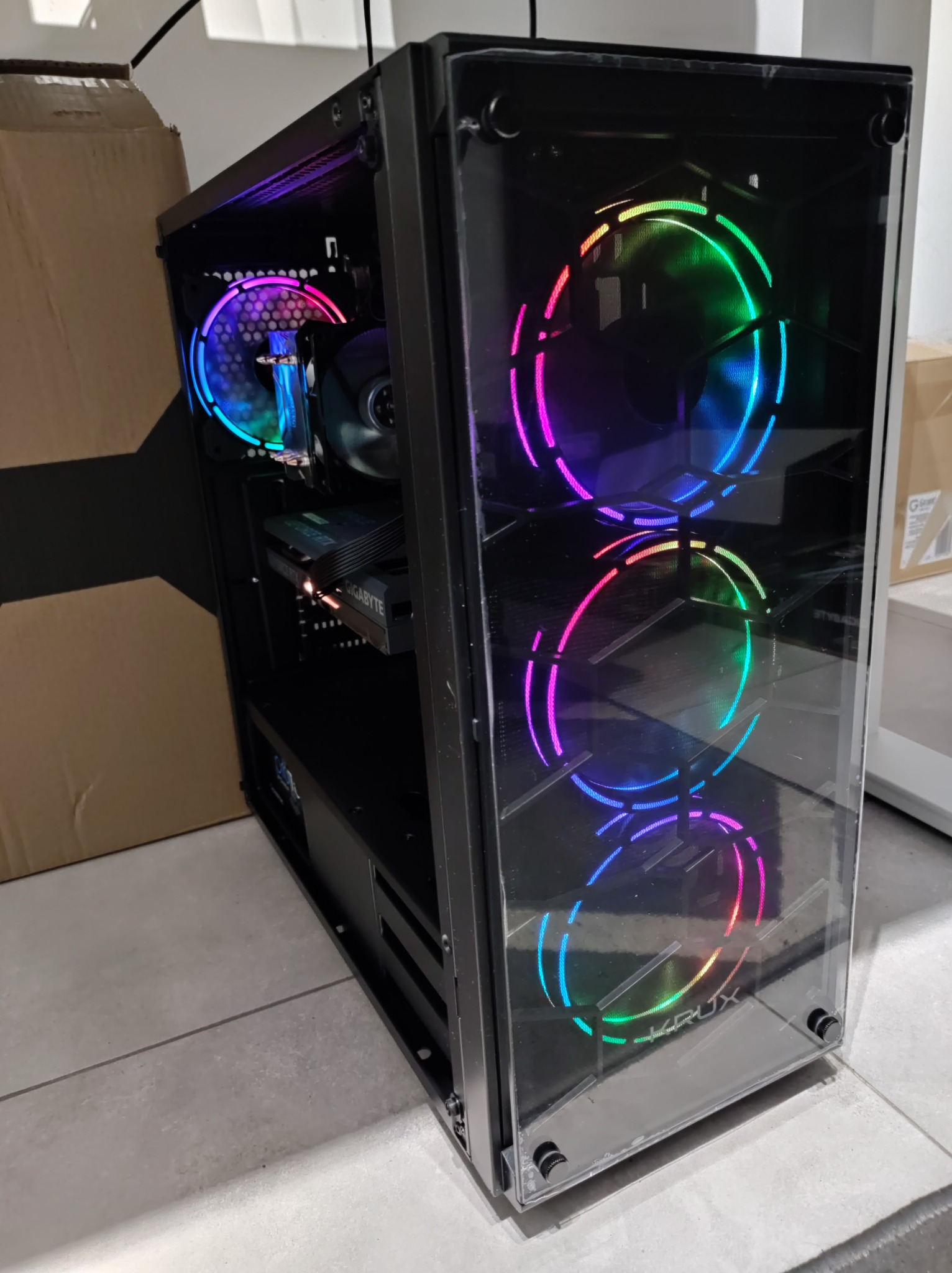 Komputer stacjonarny z podświetleniem RGB w obudowie z przezroczystym panelem bocznym, widoczna karta graficzna Gigabyte GeForce RTX.