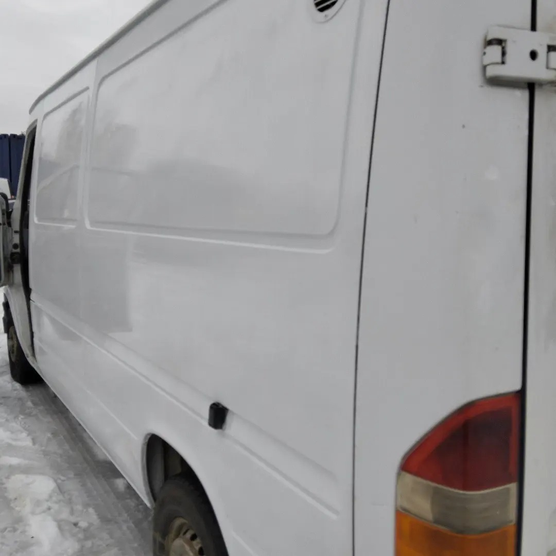 Biały samochód dostawczy z otwartymi drzwiami, widoczne ślady użytkowania i zabrudzenia na karoserii