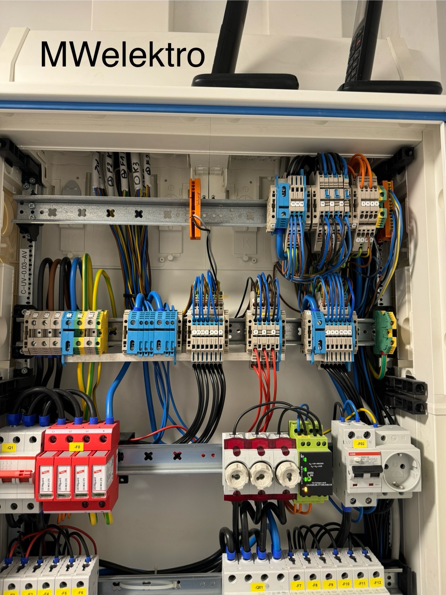 Rozdzielnica elektryczna z zainstalowanymi zabezpieczeniami przepięciowymi DehnGuard, bezpiecznikami topikowymi i wyłącznikami różnicowoprądowymi, okablowanie w kolorach niebieskim, czarnym...