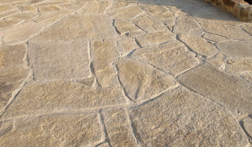 Jasna, nieregularna nawierzchnia z kamienia naturalnego, ułożona na zewnątrz, z widocznymi spoinami i delikatnym cieniem.