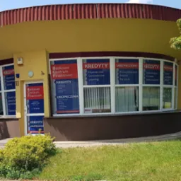 Budynek Bankowego Centrum Finansowego z reklamami kredytów hipotecznych, gotówkowych i leasingu w oknach oraz informacją o ubezpieczeniach.