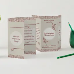 Trifoldowa broszura reklamowa gabinetu Naturopatii Kierowanej z danymi kontaktowymi Roberta Więzowskiego, obok zielony wazonik z kredkami i filiżanka z kwiatami na białym tle.