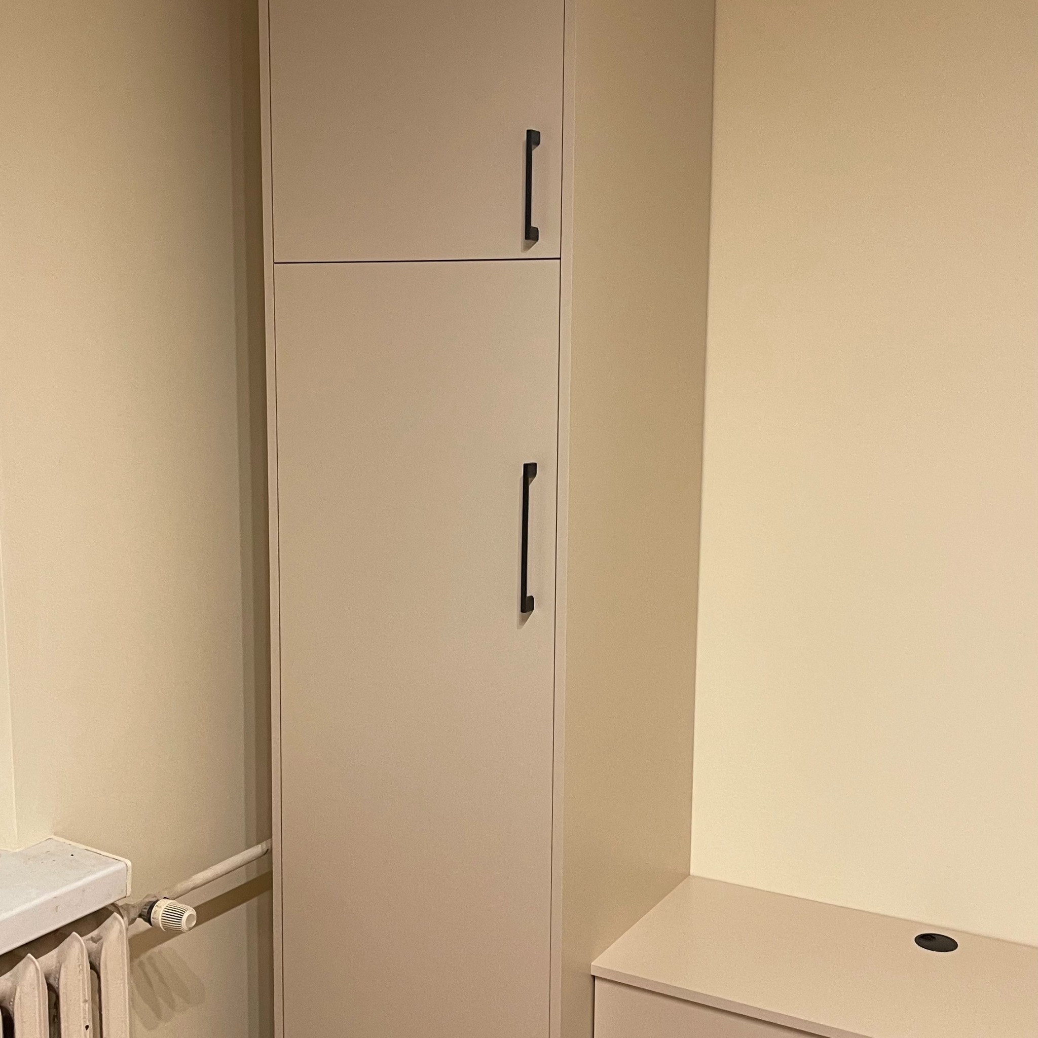 Mieszkanie z mikro kuchnią. Zabudową lodówki w salonie. Szafy zasłaniające rury. Drzwi przesuwne.