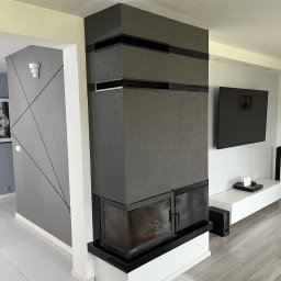 Smartdeco - Nowoczesny kominek w salonie z szarą ścianą akcentową i geometrycznym wzorem. Minimalistyczny design, jasne podłogi, telewizor na ścianie. Wykończenie wnętrz.
