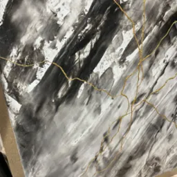 Abstrakcyjna kompozycja na ścianie z szarymi i białymi smugami farby oraz złotymi, nieregularnymi liniami przypominającymi żyłki.