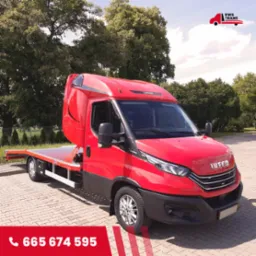 Czerwona laweta marki Iveco, zaparkowana na brukowanym placu, z widocznym logo firmy RWS Trans w prawym górnym rogu i numerem telefonu w lewym dolnym rogu.