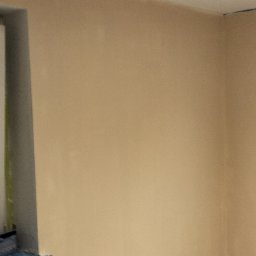 Krzysztof Zdun - Ściana po szpachlowaniu, widoczne nierówności i przygotowanie do dalszych prac wykończeniowych, dwa halogeny w suficie, grzejnik pod oknem przykryty folią.