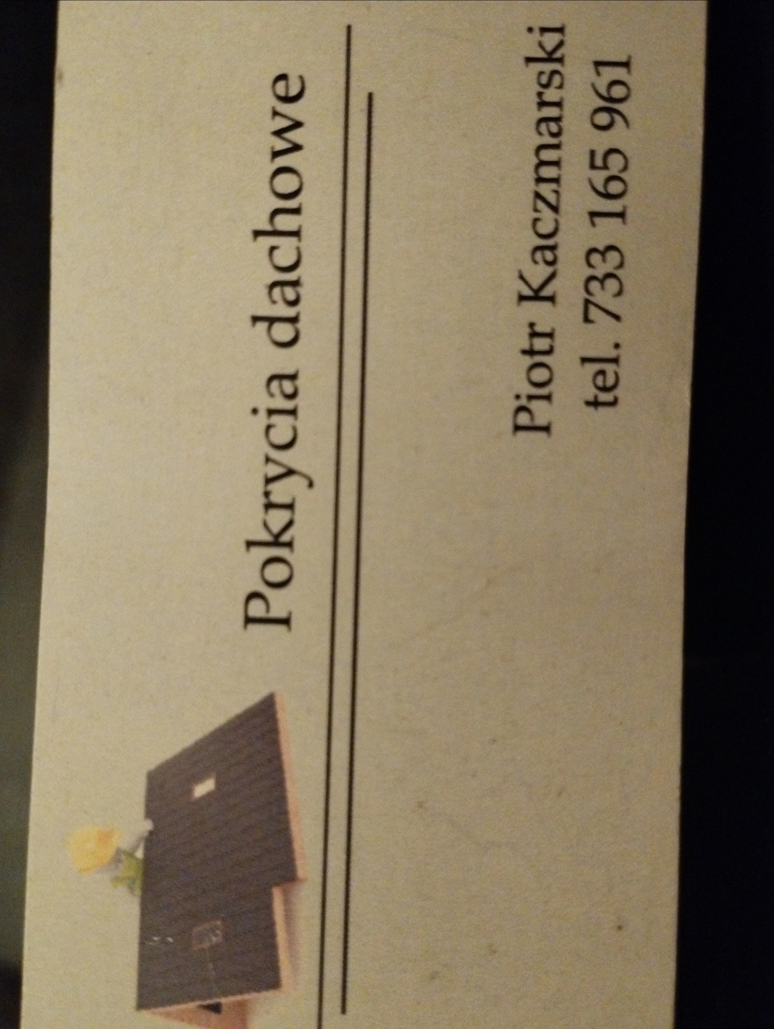 Wizytówka firmy dekarskiej Piotra Kaczmarskiego z miniaturą dachu i napisem 'Pokrycia dachowe' oraz numerem telefonu.