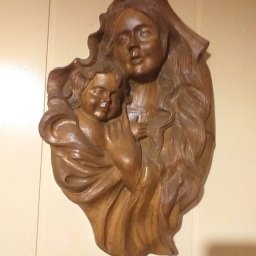 Klimkówka - Ręcznie rzeźbiona w drewnie płaskorzeźba przedstawiająca Madonnę z Dzieciątkiem, zawieszona na ścianie z boazerią.