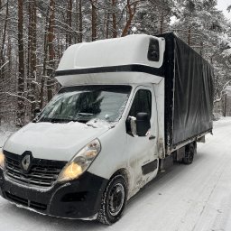BNO-TRANS - Biały bus Renault z czarną plandeką, ośnieżony, stoi na drodze w zimowym lesie. Widoczne ślady opon na śniegu i drzewa pokryte szronem.