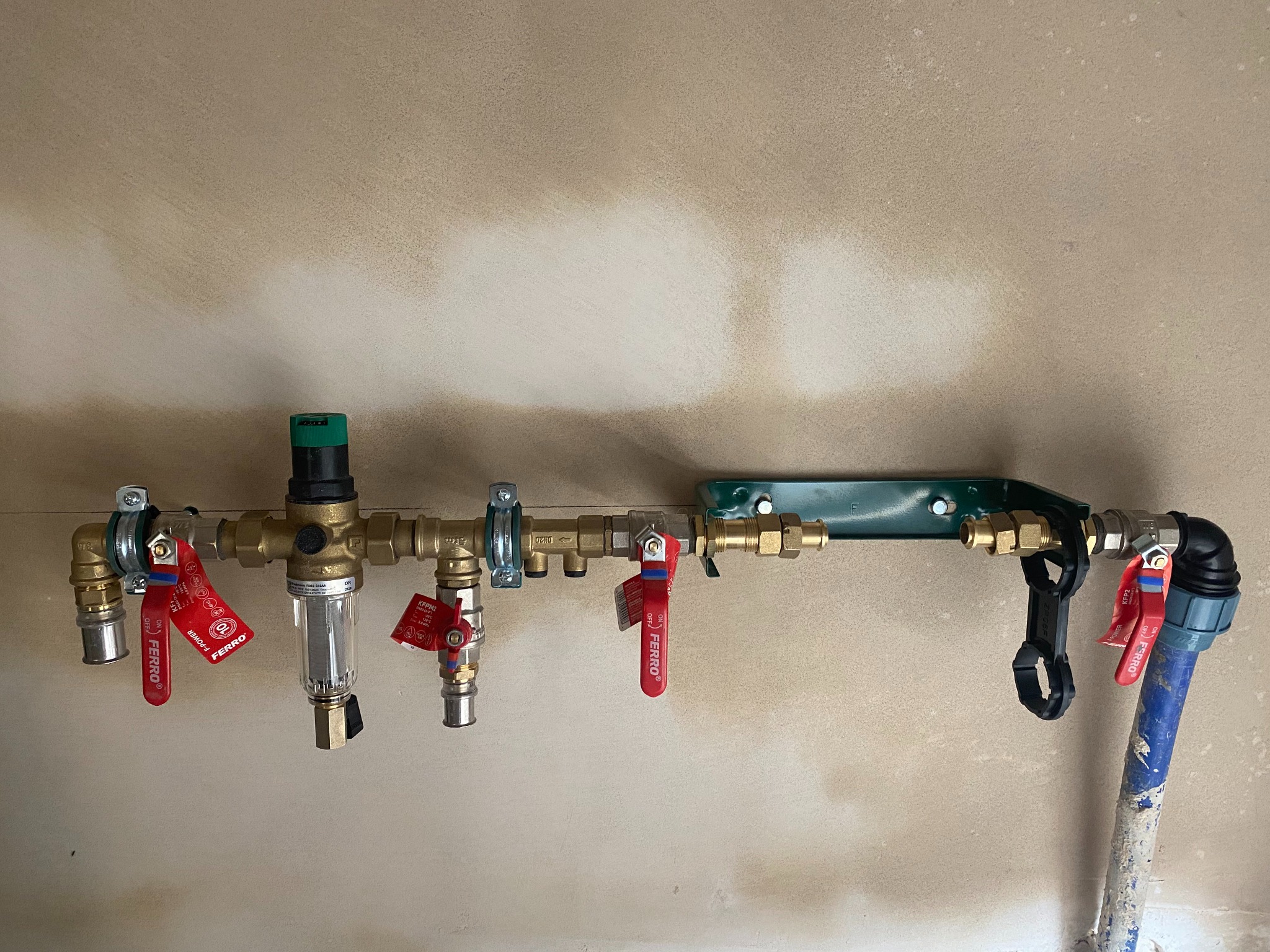 Nowa instalacja wodna z filtrem i zaworami Ferro, zamontowana na ścianie w trakcie wykończenia.