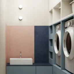 Nowoczesna pralnia z umywalką, pralkami w zabudowie i pastelową kolorystyką ścian, tworząca spójną i funkcjonalną przestrzeń. Minimalistyczny design.