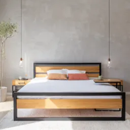 Drewniane łóżko z czarną metalową ramą, minimalistyczne szafki nocne z lampkami i wiszącymi żarówkami, na ścianie szary tynk dekoracyjny, obok okna donica z drzewkiem.