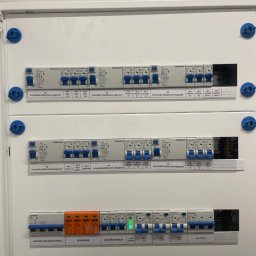 Electro4you - Rozdzielnica elektryczna Schrack z wyłącznikami różnicowoprądowymi i bezpiecznikami, z opisami obwodów, zamontowana w białej obudowie. Widoczne oznaczenia gniazd.