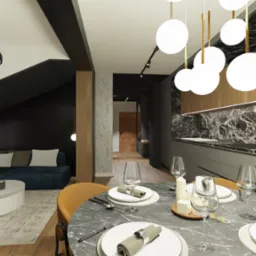 Wnętrze mieszkania z otwartą kuchnią, jadalnią i salonem; widoczny stół z marmurowym blatem i nakryciem, nowoczesna zabudowa kuchenna z czarnym marmurem, narożnik w salonie pod skosem dachu...
