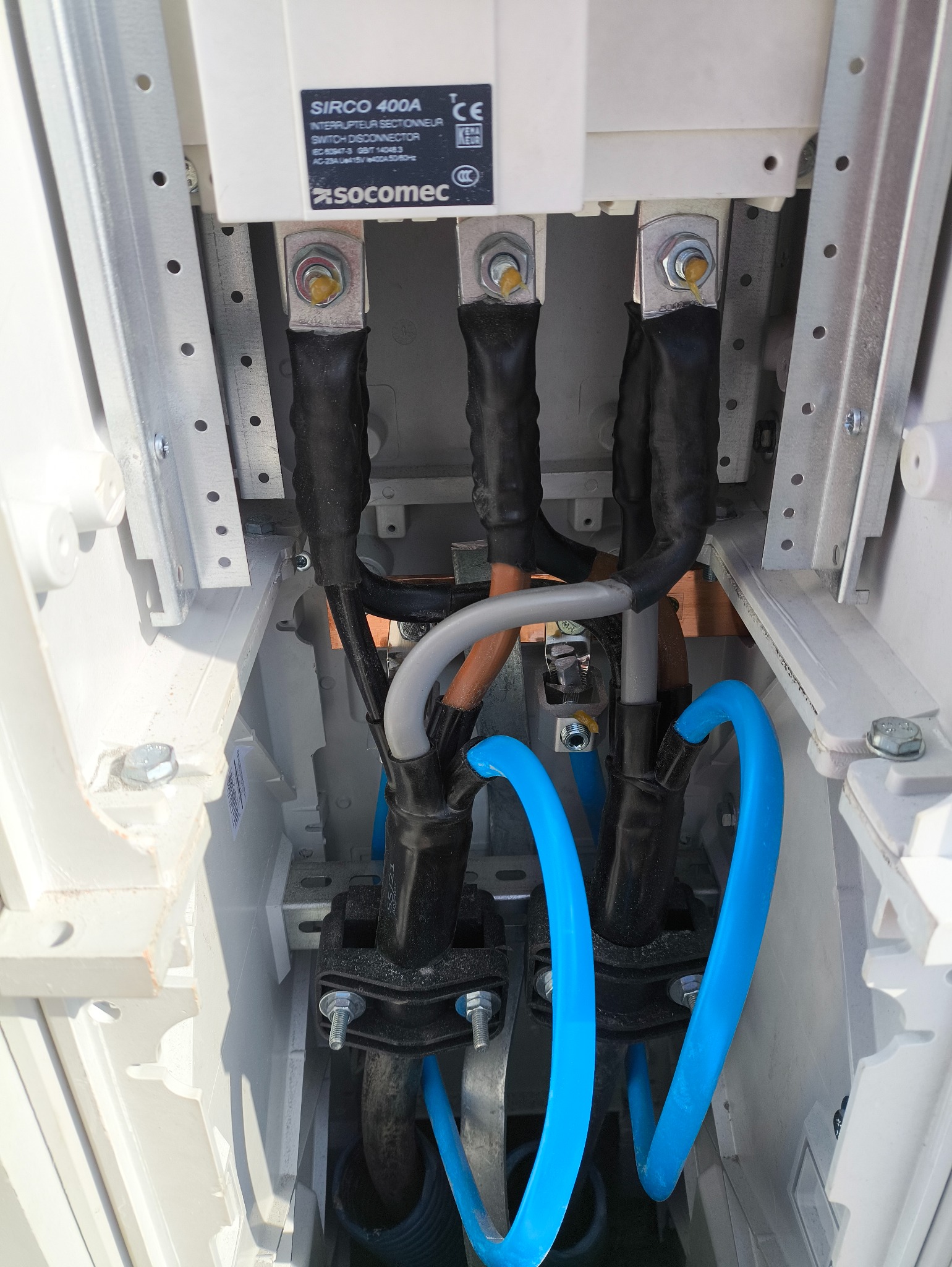 Rozdzielnica elektryczna z widocznymi przewodami, złączami i elementami montażowymi. Detal instalacji z bliska, w jasnej obudowie.