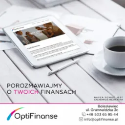 Tablet wyświetlający stronę internetową firmy finansowej OptiFinanse, leżący na białym drewnianym biurku obok filiżanki kawy i białego długopisu.