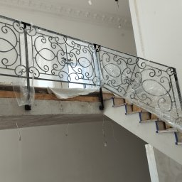 BSL Welding Art - Kute balustrady schodowe w folii ochronnej podczas montażu w Parczewie. Elementy dekoracyjne z motywem roślinnym. Wykończenie w kolorze czarnym.