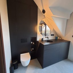 KLBR Meble Łukasz Kaleta - Nowoczesna łazienka na poddaszu z czarnymi meblami: szafa w zabudowie, umywalka z szafką, okrągłe lustro z oświetleniem LED. Biała toaleta i szara podłoga.