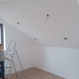 BiG-Max - Poddasze po malowaniu w Wielgus. Widoczne halogeny w suficie, drabina i fragment podłogi. W tle okno.