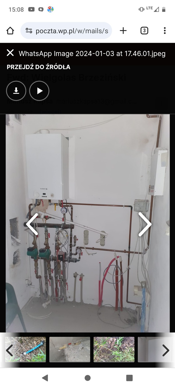 Nowy piec gazowy wiszący na ścianie w kotłowni, z widoczną instalacją hydrauliczną z licznymi rurami miedzianymi, zaworami i pompami obiegowymi. Ściany kotłowni są pomalowane na biało, a...