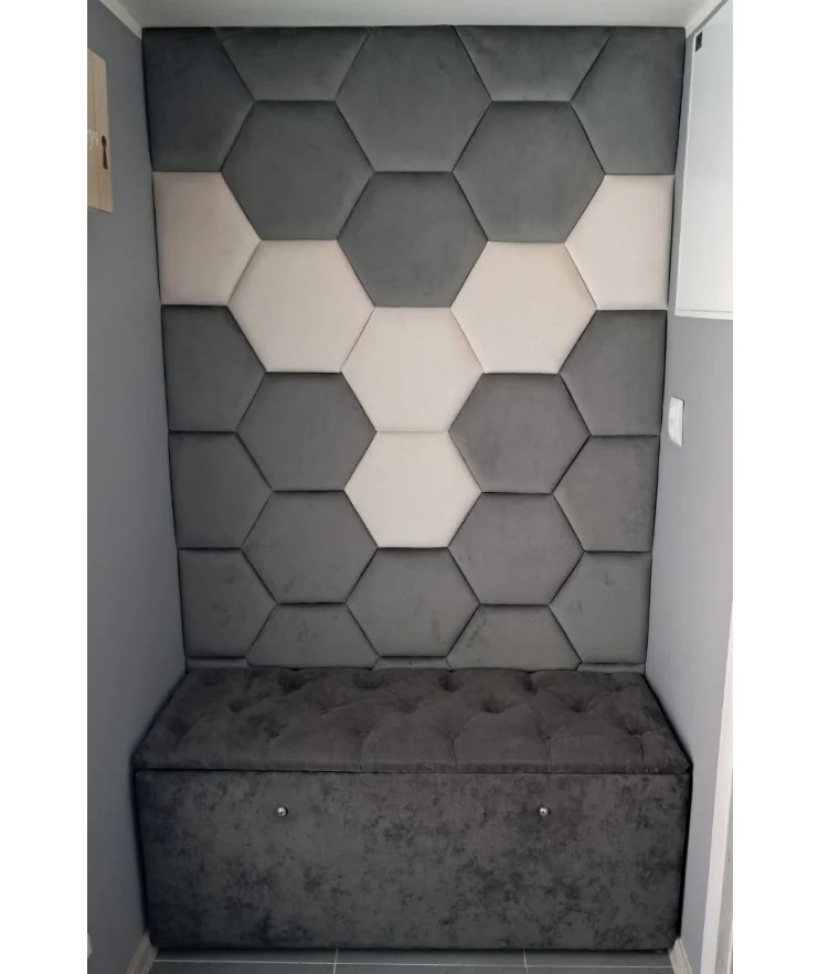 Tapicerowana ściana z sześciokątnych paneli w odcieniach szarości i bieli, z dopasowaną tapicerowaną ławką ze schowkiem w przedpokoju.