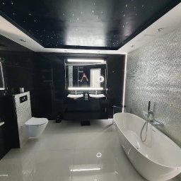 EPP Oskar Kasperkowiak - Luksusowa łazienka z czarnymi marmurowymi ścianami, błyszczącą mozaiką, podwieszanym sufitem imitującym nocne niebo, wolnostojącą wanną i podwójną umywalką z podświetlanym lustrem, uchwycona...