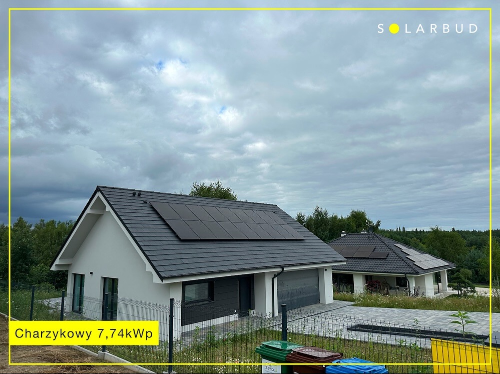 Dwa domy jednorodzinne z panelami słonecznymi na dachu, instalacja fotowoltaiczna w Chojnicach. Widok z poziomu gruntu, pochmurne niebo.