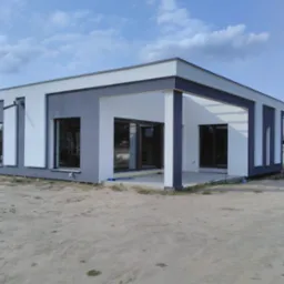 Nowoczesny dom jednorodzinny z płaskim dachem, wykończony w kolorach szarości i bieli, z dużymi przesuwnymi oknami tarasowymi i odkrytym zadaszeniem tarasu.