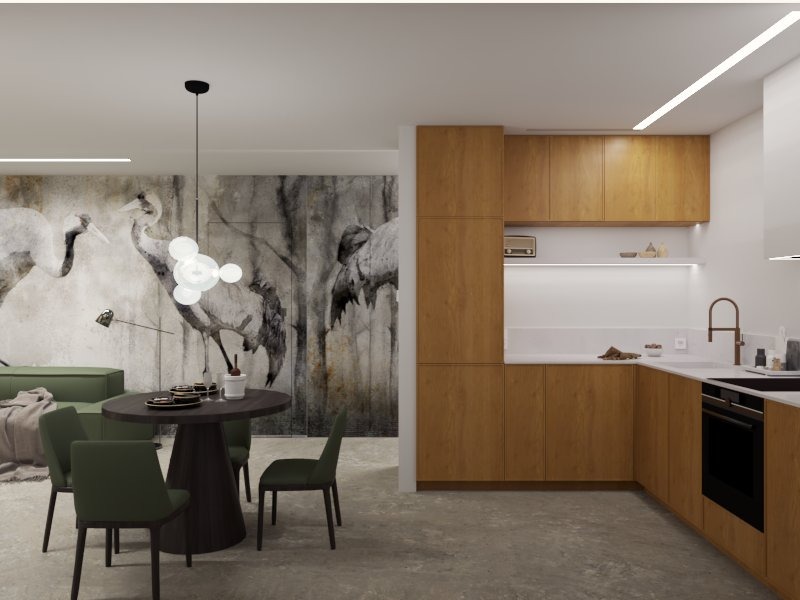 Wnętrze mieszkania z aneksem kuchennym, drewniane szafki kuchenne, okrągły stół z ciemnego drewna i krzesła w odcieniach zieleni, na ścianie tapeta z motywem żurawi, nowoczesna lampa wisząca...