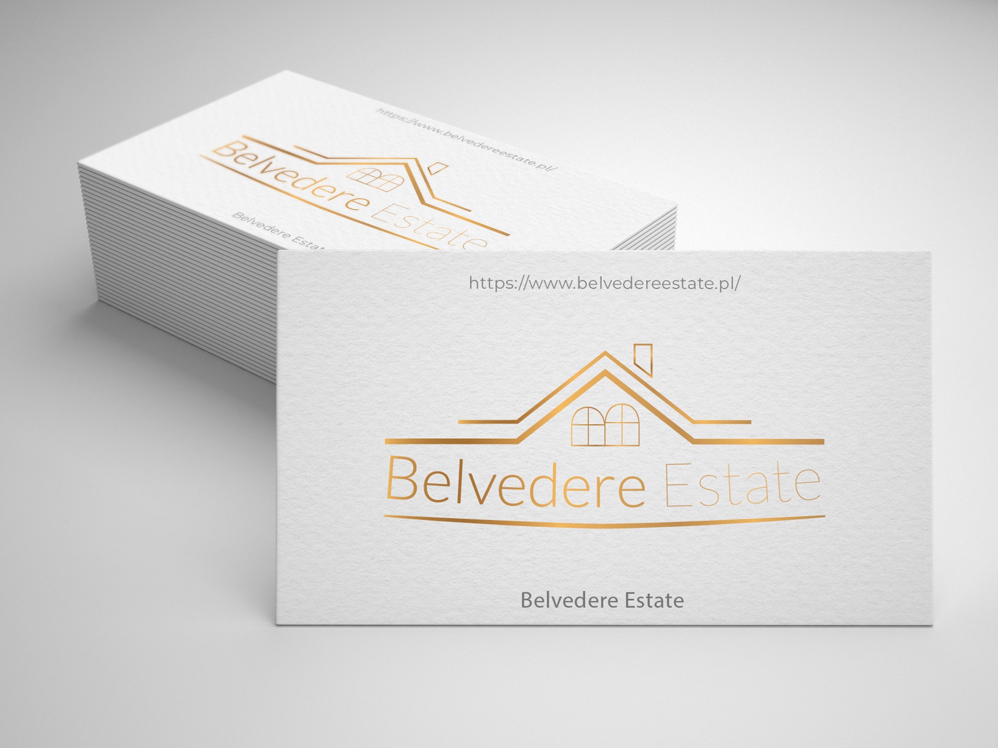 Stos wizytówek z minimalistycznym złotym logo domu i tekstem 'Belvedere Estate' na teksturowanym białym papierze.