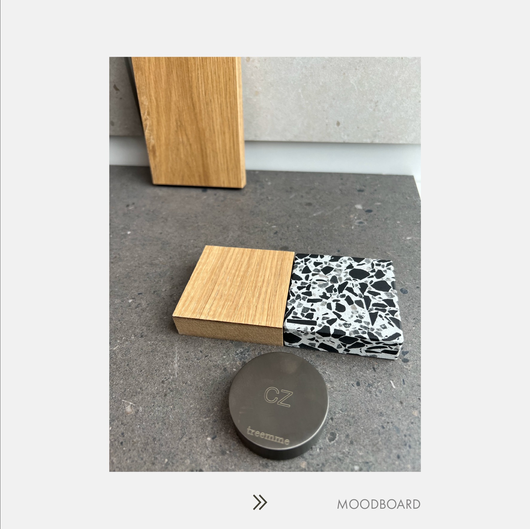 Moodboard z próbkami materiałów: drewno dębowe, lastryko oraz metalowy krążek z logo 'treemme CZ' na tle szarego blatu.
