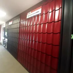 Ekspozycja w sklepie: panele blachodachówki KORA w kolorze czerwonym i szarym, prezentacja wzorów.