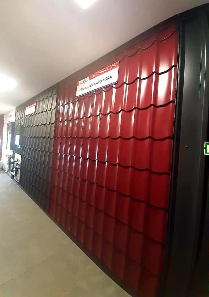 Ekspozycja w sklepie: panele blachodachówki KORA w kolorze czerwonym i szarym, prezentacja wzorów.