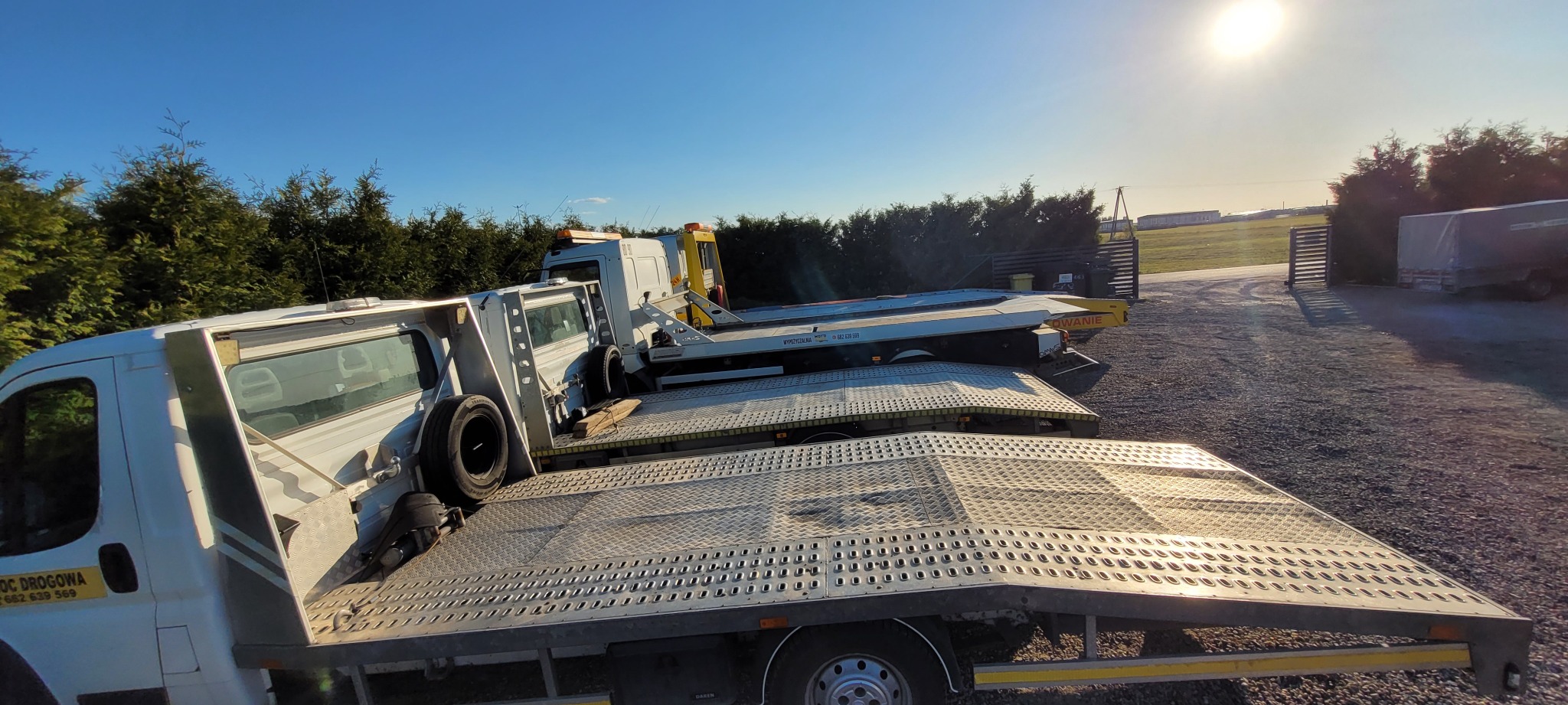 Kilka lawet ustawionych jedna za drugą na placu w słoneczny dzień; widoczne detale konstrukcji lawet i otoczenie.