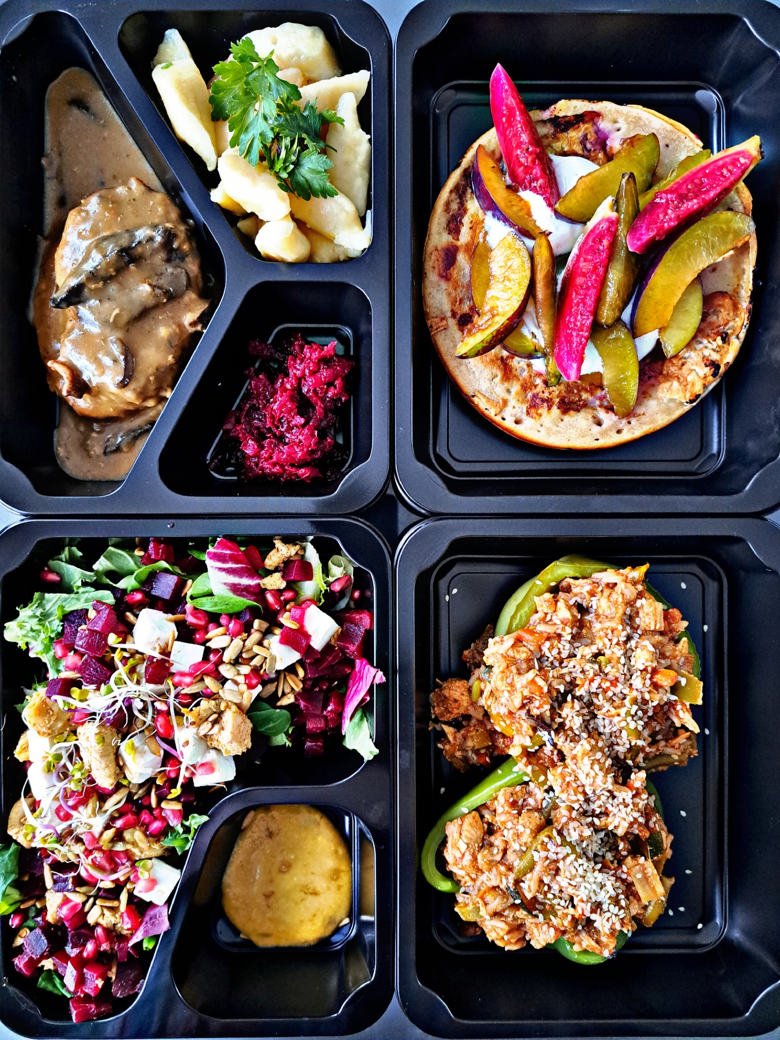 Czterodaniowy posiłek dietetyczny w czarnym opakowaniu: kotlet w sosie grzybowym, kopytka z pietruszką, sałatka z burakiem i fetą, naleśnik z owocami i sosem.