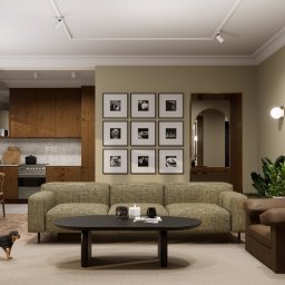 EMILIA MATYJASZCZYK ARCHITEKT WNĘTRZ - Wnętrze salonu z aneksem kuchennym w neutralnych barwach, sofa z wzorzystą tapicerką, czarny owalny stolik kawowy, na ścianie galeria czarno-białych fotografii, brązowy fotel i pies rasy rottweiler...