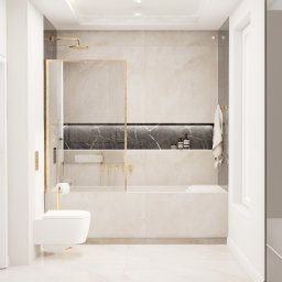 EMILIA MATYJASZCZYK ARCHITEKT WNĘTRZ - Elegancka łazienka w jasnych beżach z złotymi akcentami, kabina prysznicowa typu walk-in, podwieszana toaleta, marmurowa ściana z półką i kosmetykami, widok na zieleń przez okno.
