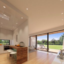 M11 architekci - Jasne wnętrze domu z otwartą kuchnią, drewnianym blatem barowym i widokiem na ogród przez duże okna przesuwne.