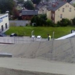 ZRBH Dragon Paweł - Prace na dachu płaskim budynku z widocznymi dwoma pracownikami i materiałami budowlanymi, w tle zabudowa miejska i zieleń.