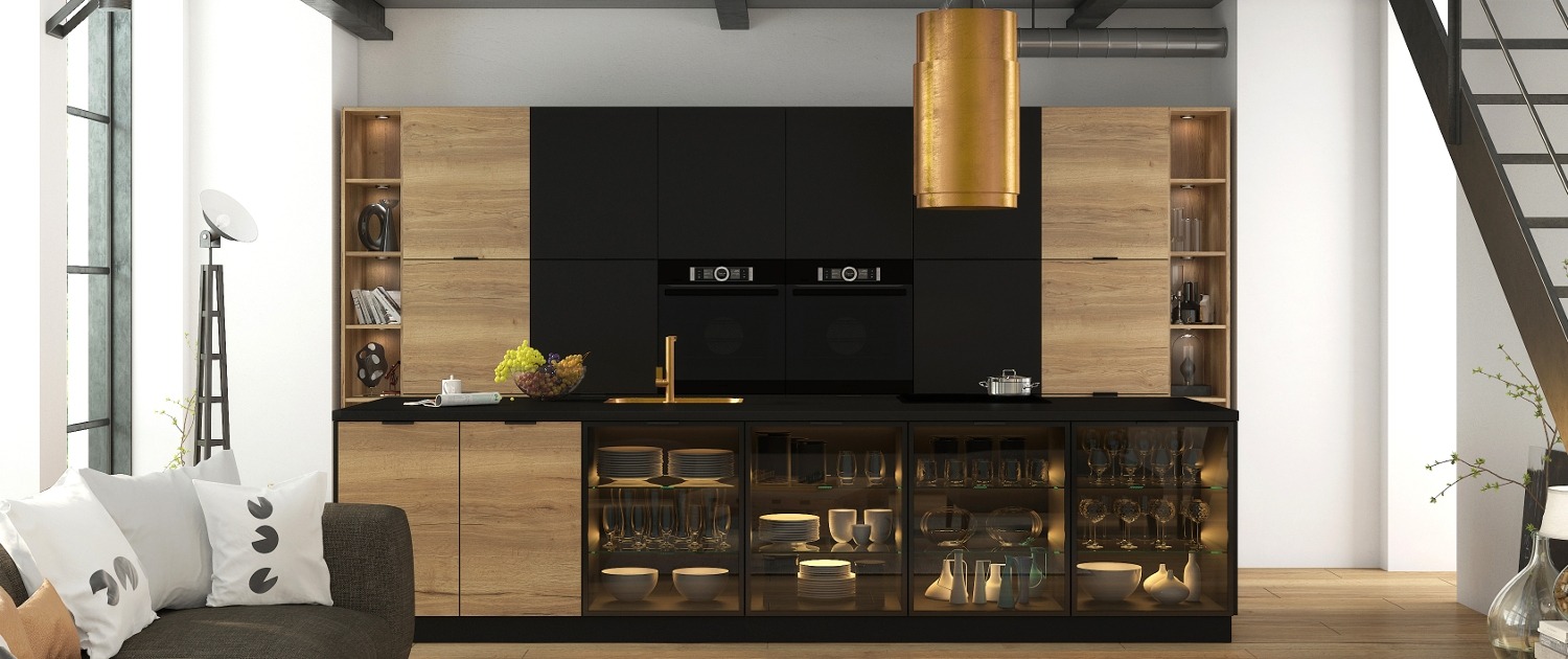 Nowoczesna kuchnia z czarnymi frontami i drewnopodobnymi akcentami, złota armatura i lampa, szklane witryny z oświetleniem eksponują zastawę, minimalistyczny design z widocznymi schodami.